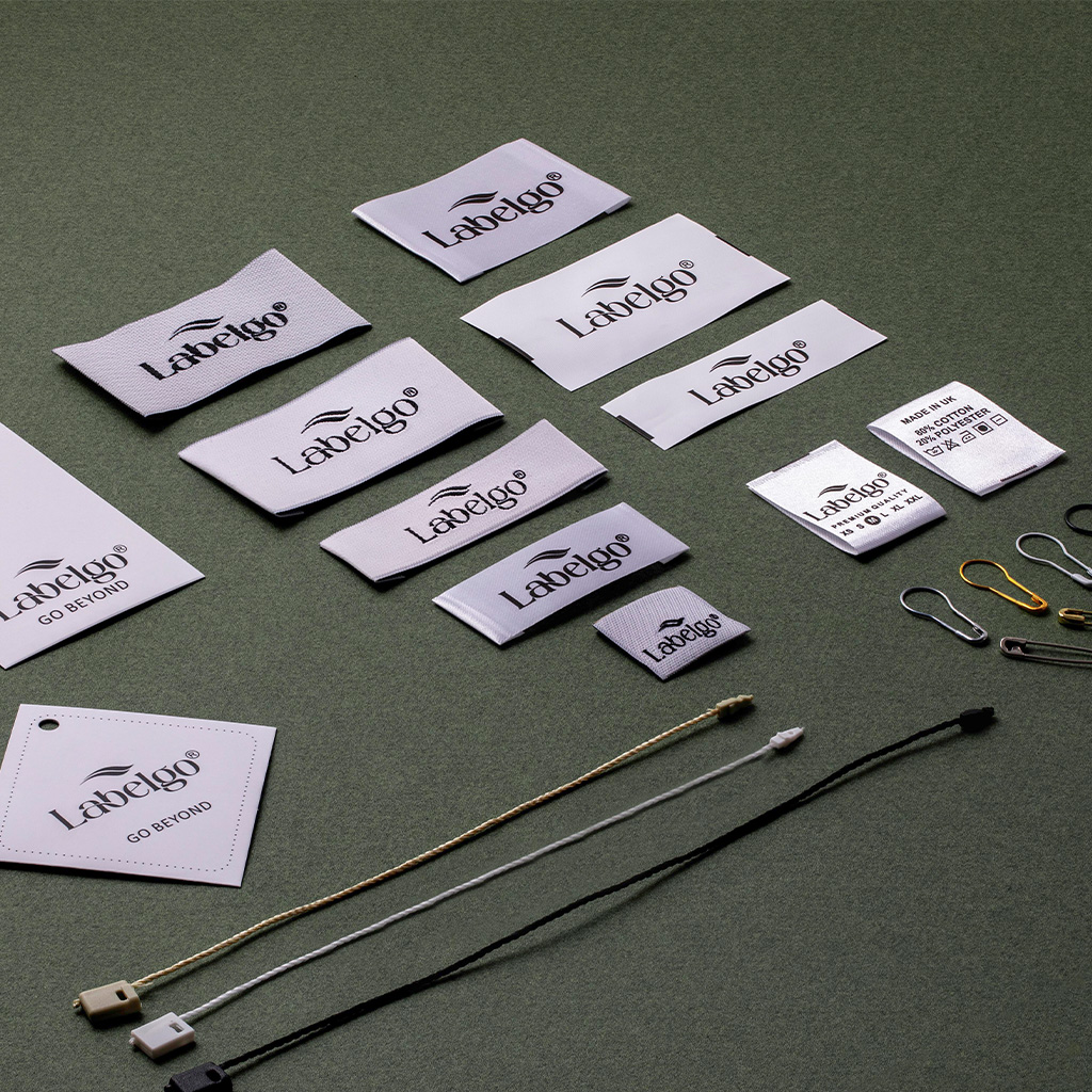 Collezione assortita di etichette in tessuto bianco ricamate con loghi neri per campionario.