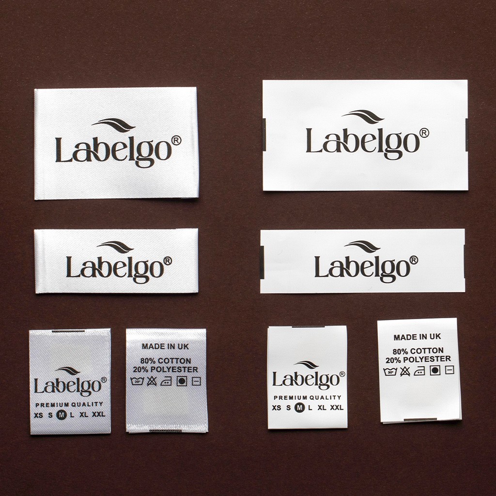 Set di etichette in tessuto bianco LabelGo con loghi neri per campionario moda.
