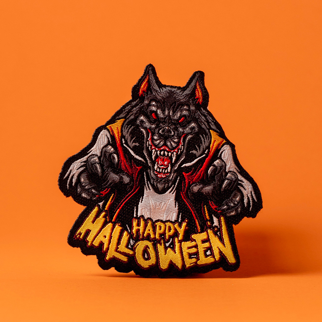 Patch ricamata lupo mannaro rosso e nero per Halloween su sfondo arancione intenso.