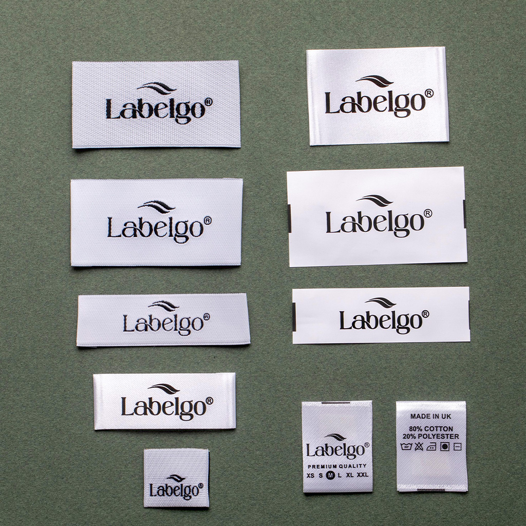 Set di etichette in tessuto bianco LabelGo con loghi neri per campionario moda.