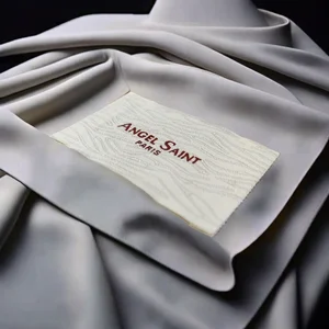 Etichette In Poliestere Personalizzate: Alta Densità e Durata 3 Etichette In Poliestere Personalizzate mostrato come esempio di produzione di etichette tessili con cartellino, etichetta taglia e toppa tessile